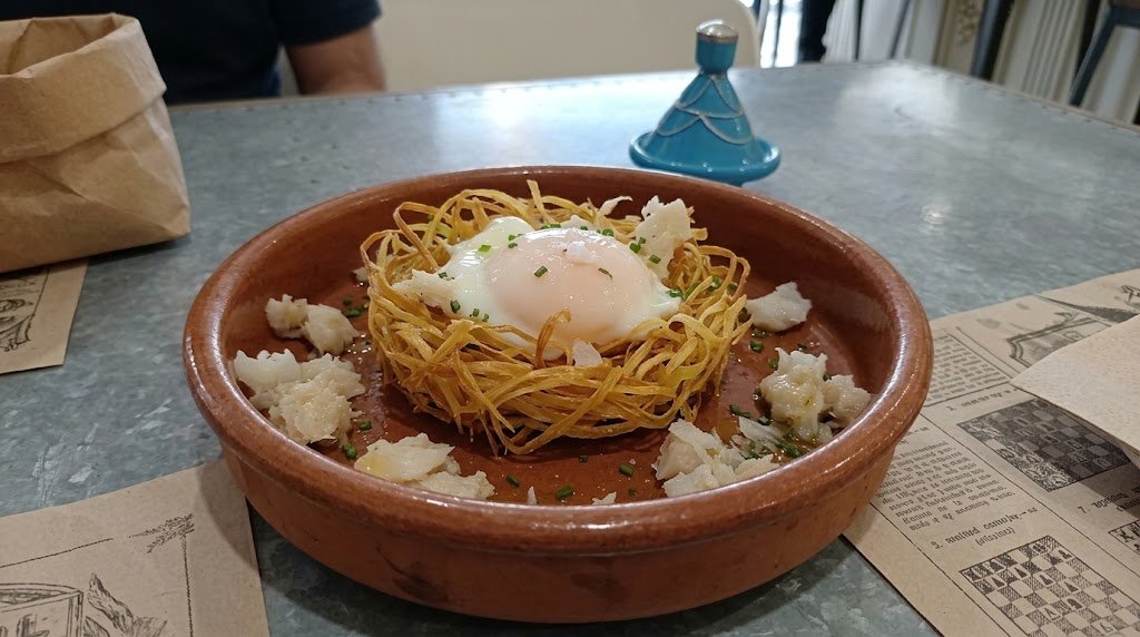 Huevo escalfado sobre nido de puerro frito y bacalao